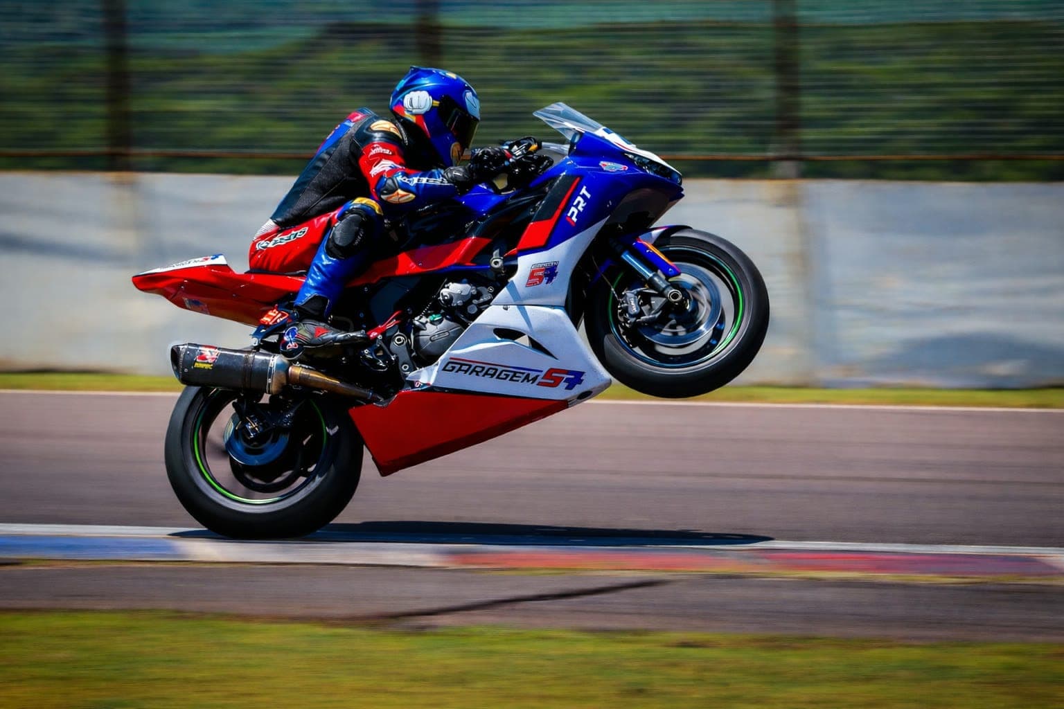 Hilton empinando a moto #76 em pista — outro ângulo